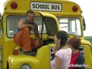 Two teen girls helping a bus driver